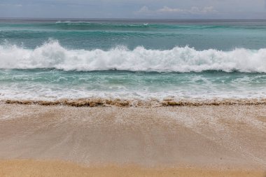 Deniz manzaralı arka plan. Kumsal, süt köpüğü dalgaları, mavi okyanus. Manzaralı su manzarası. Ufuk çizgisi. Doğa ve çevre kavramı. Gün ışığı. Uzayı kopyala Rüya Diyarı Sahili, Bali Endonezya