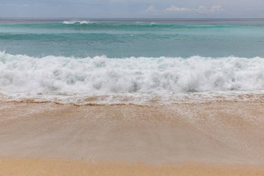 Deniz manzaralı arka plan. Kumsal, süt köpüğü dalgaları, mavi okyanus. Manzaralı su manzarası. Ufuk çizgisi. Doğa ve çevre kavramı. Gün ışığı. Uzayı kopyala Rüya Diyarı Sahili, Bali Endonezya