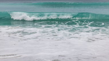 Deniz manzaralı arka plan. Kumsal, süt köpüğü dalgaları, mavi okyanus. Manzaralı su manzarası. Doğa ve çevre kavramı. Gün ışığı. Uzayı kopyala Rüya Diyarı Sahili, Bali Endonezya