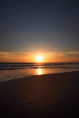 Gün batımı ve sahil. Deniz manzaralı arka plan. Parlak güneş ışığı. Güneş ufukta görünüyor. Manzaralı. Gün batımı altın saati. Suda güneş ışığı yansıması. Muhteşem bir manzara. Uzayı kopyala Bali, Endonezya