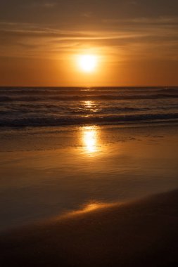 Gün batımı ve sahil. Deniz manzaralı arka plan. Parlak güneş ışığı. Güneş ufukta görünüyor. Manzaralı. Gün batımı altın saati. Suda güneş ışığı yansıması. Muhteşem bir manzara. Uzayı kopyala Bali, Endonezya