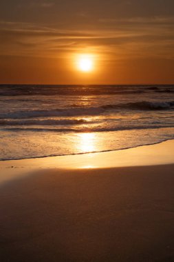 Gün batımı ve sahil. Deniz manzaralı arka plan. Parlak güneş ışığı. Güneş ufukta görünüyor. Manzaralı. Gün batımı altın saati. Suda güneş ışığı yansıması. Muhteşem bir manzara. Uzayı kopyala Bali, Endonezya