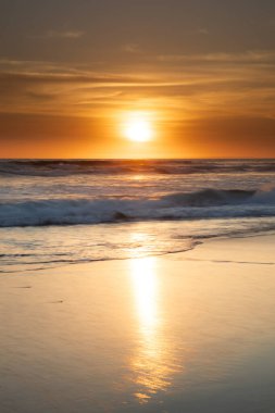Gün batımı ve sahil. Deniz manzaralı arka plan. Parlak güneş ışığı. Güneş ufukta görünüyor. Manzaralı. Gün batımı altın saati. Suda güneş ışığı yansıması. Muhteşem bir manzara. Uzayı kopyala Bali, Endonezya