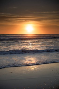 Gün batımı ve sahil. Deniz manzaralı arka plan. Parlak güneş ışığı. Güneş ufukta görünüyor. Manzaralı. Gün batımı altın saati. Suda güneş ışığı yansıması. Muhteşem bir manzara. Uzayı kopyala Bali, Endonezya