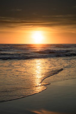 Gün batımı ve sahil. Deniz manzaralı arka plan. Parlak güneş ışığı. Güneş ufukta görünüyor. Manzaralı. Gün batımı altın saati. Suda güneş ışığı yansıması. Muhteşem bir manzara. Uzayı kopyala Bali, Endonezya