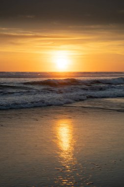 Gün batımı ve sahil. Deniz manzaralı arka plan. Parlak güneş ışığı. Güneş ufukta görünüyor. Manzaralı. Gün batımı altın saati. Suda güneş ışığı yansıması. Muhteşem bir manzara. Uzayı kopyala Bali, Endonezya