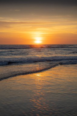Gün batımı ve sahil. Deniz manzaralı arka plan. Parlak güneş ışığı. Güneş ufukta görünüyor. Manzaralı. Gün batımı altın saati. Suda güneş ışığı yansıması. Muhteşem bir manzara. Uzayı kopyala Bali, Endonezya