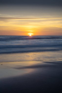 Gün batımı ve sahil. Deniz manzaralı arka plan. Parlak güneş ışığı. Güneş ufukta görünüyor. Manzaralı. Gün batımı altın saati. Suda güneş ışığı yansıması. Muhteşem bir manzara. Uzayı kopyala Bali, Endonezya