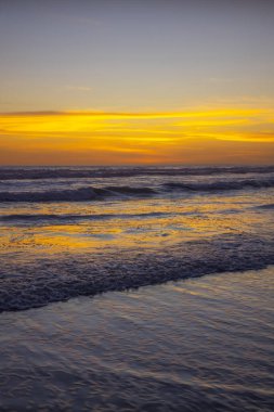 Kumsalda sarı gün batımı. Arka plan için deniz manzarası. Renkli gökyüzü. Güzel su yansıması. Ufuk çizgisinde güneş ışığı. Doğa ve çevre kavramı. Uzayı kopyala Endonezya, Bali 'de Günbatımı.