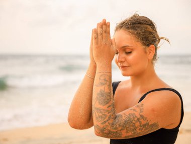 namaste Mudra 'yı kapatın. Çekici beyaz kadın sahilde yoga ve meditasyon yapıyor. Eller namaste 'de. Kapalı gözler. Yoga konsepti. Uzayı kopyala Thomas Sahili, Bali, Endonezya