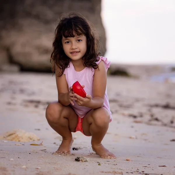 Chica Joven Sentada Playa Arena Sosteniendo Juguete Rojo Cálido Día —  Fotos de Stock