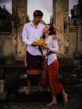 Bali seremonisi için hazırlık. Çok kültürlü bir çift, Hindu dini törenine hazırlanıyor. Tanrı 'nın adaklarıyla. Kültür ve din. Beyaz bir eş ve Balili bir koca. Penglipuran, Bali