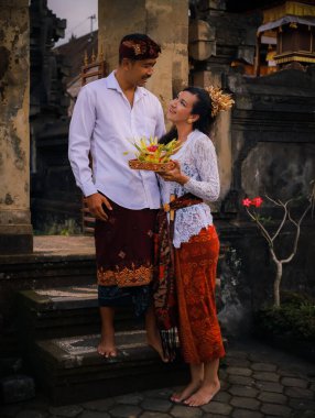 Bali seremonisi için hazırlık. Çok kültürlü bir çift, Hindu dini törenine hazırlanıyor. Tanrı 'nın adaklarıyla. Kültür ve din. Beyaz bir eş ve Balili bir koca. Penglipuran, Bali
