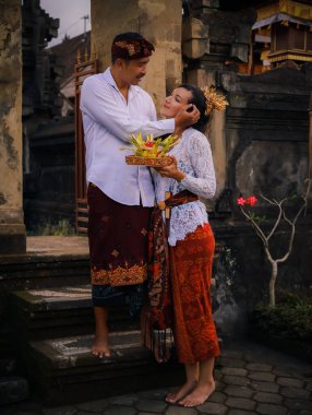Bali seremonisi için hazırlık. Çok kültürlü bir çift, Hindu dini törenine hazırlanıyor. Tanrı 'nın adaklarıyla. Kültür ve din. Beyaz bir eş ve Balili bir koca. Penglipuran, Bali