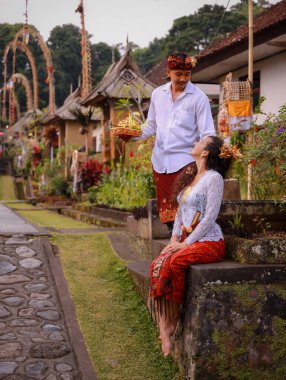 Bali seremonisi için hazırlık. Çok kültürlü bir çift, Hindu dini törenine hazırlanıyor. Tanrı 'nın adaklarıyla. Kültür ve din. Beyaz bir eş ve Balili bir koca. Penglipuran, Bali