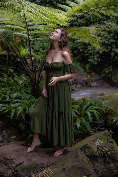 女性のジャングルの中では シダの下に立って 緑のドレスを着て 熱帯雨林を歩く白人女性 自然と環境の概念 アジアへの旅行 インドネシアのバリ島 — ストック写真