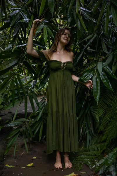 美しい女性は熱帯雨林の中を歩くと 長い緑のドレスを着ている 竹の葉に触れるジャングルの中の女性 自然と環境の概念 アジアへの旅行 インドネシアのバリ島 — ストック写真
