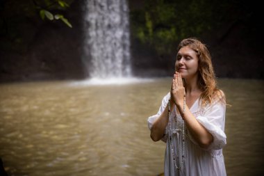 Kafkasyalı kadın dua ve meditasyon sırasında saymaya devam ediyor. Budist japa malası. Değerli boncuk iplikleri. Din kavramı. Budist mücevherleri. Eller namaste mudra 'da. Uzayı kopyala Bali, Endonezya