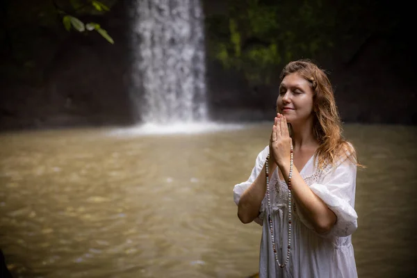 Kafkasyalı kadın dua ve meditasyon sırasında saymaya devam ediyor. Budist japa malası. Değerli boncuk iplikleri. Din kavramı. Budist mücevherleri. Eller namaste mudra 'da. Uzayı kopyala Bali, Endonezya