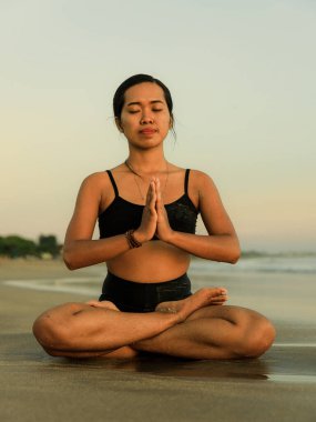 Yoga inzivası. Lotus pozu veren Asyalı kadın. Padmasana. Eller namaste mudra 'da. Kapalı gözler. Sağlıklı bir yaşam tarzı. Sahilde yoga. Mükemmel bir vücut. Seminyak Sahili, Bali, Endonezya