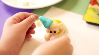 Badem ezmesi modellemesinin el yapımı figürleri, pasta ve turtalar için tatlı süslemeler hazırlamak, çocuk elleri, badem ezmesi 