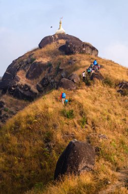Turistler Myanmar 'ın Mulayit Dağı tepesindeki Pagoda tepesine doğru yürüyorlar..