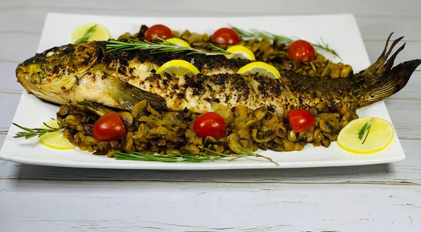Sebzeli fırında balık. Diyet balık yemeği. Soğanlı ve mantarlı sazan balığı..