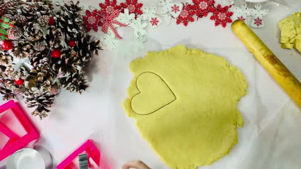 La femme coupe les cookies sous la forme d'un cœur. — Video