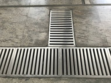 Paslanmaz çelik kaplama ya da imâl edilmiş döşeme, metro istasyonundaki mermer döşemede boydan boya ızgara.