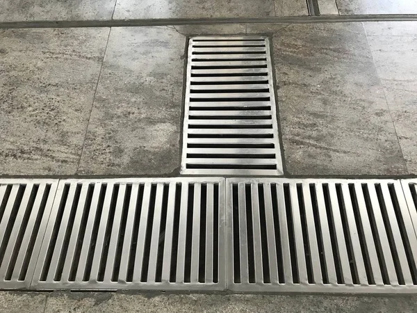 Paslanmaz çelik kaplama ya da imâl edilmiş döşeme, metro istasyonundaki mermer döşemede boydan boya ızgara.