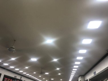 Bir tekstil dükkanı reklamı için beyaz LED ışıklandırmalı alçıtaşı sahte tavan tasarımı