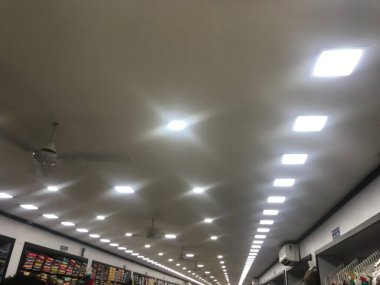 Bir tekstil dükkanı reklamı için beyaz LED ışıklandırmalı alçıtaşı sahte tavan tasarımı