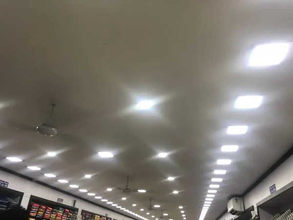 Bir tekstil dükkanı reklamı için beyaz LED ışıklandırmalı alçıtaşı sahte tavan tasarımı
