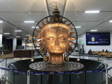 Altın rengi büyük başlı Buddha heykeli. İçi kapalı fıskiyenin içinde içi kapalı. Ya da içi kapalı kamu binası.