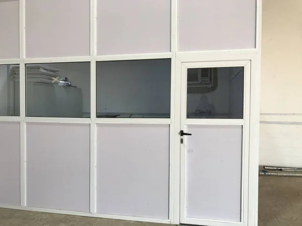 Semi glazed door and panels made of aluminum for an warehouse office installed on a concrete floor