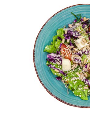 Beyaz arka planda bir tabak taze, lezzetli salata, izole. Salata, salata, domates, tohum, salatalık ve peynir. Yukarıdan görünüşü.