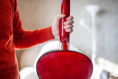 Bir gitaristin ya da akustik gitar çalmayı öğrenen birinin yakın çekimi. Evde müzik aleti çalmayı öğreniyorum.