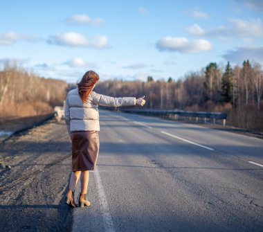 Kız otoyolda arabayı eliyle durdurdu. Yoldaki şık kadın arabayı durdurur ve bir yolculuğa çıkar. Ormanın ortasında bir yol..