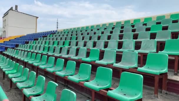 選手も観客もいないスタジアムの列の黄色 青の席 Covid 19コロナウイルスパンデミックの間の空のスタジアムやレーストラックの座席 — ストック動画