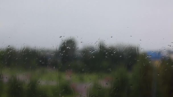 Βροχερή μέρα μέσα από το παράθυρο στον ουρανό και την πόλη κτίρια φόντο — Αρχείο Βίντεο