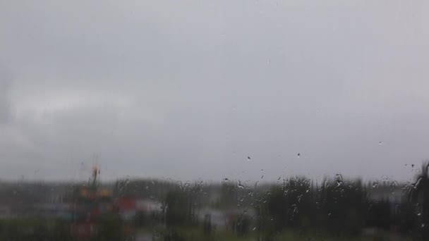 Dia chuvoso através da janela no céu e edifícios da cidade fundo — Vídeo de Stock