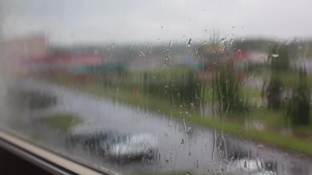 Jour de pluie à travers la fenêtre sur le ciel et les bâtiments de la ville fond — Video