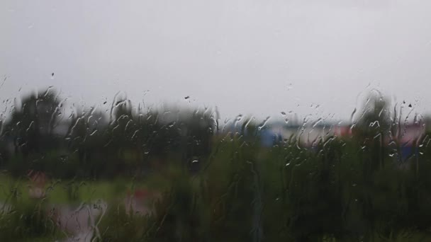 Jour de pluie à travers la fenêtre sur le ciel et les bâtiments de la ville fond — Video