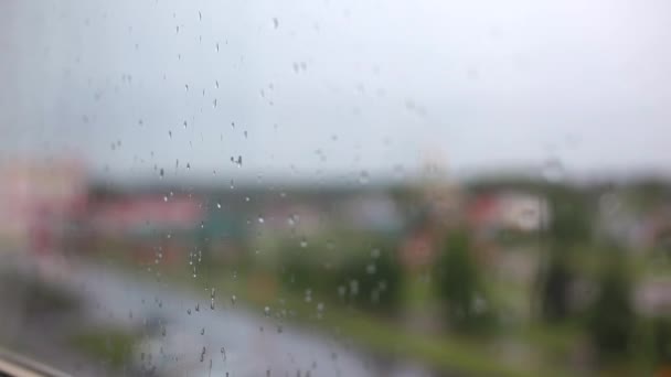 Jour de pluie à travers la fenêtre sur le ciel et les bâtiments de la ville fond — Video