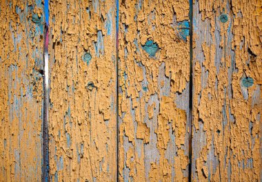 Sarı pul pul boyanmış ahşap doku. Yıpranmış ahşabın boyası soyuluyor