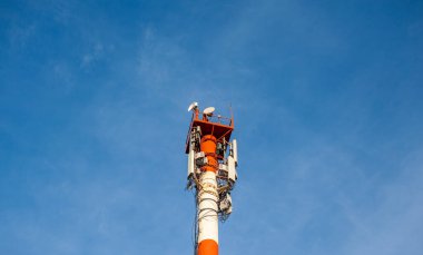 Telekomünikasyon teknolojisi GSM 5G, 4G, 3G kulesi. Bir binanın çatısında cep telefonu antenleri. Telekomünikasyon direği televizyon antenleri alınıyor ve iletiliyor.