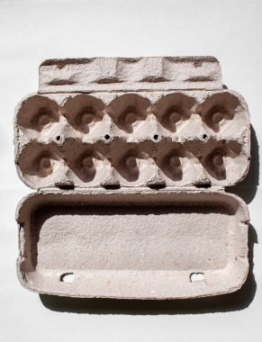 Beyaz arka planda yumurtasız gri yumurta kutusu. Geri dönüştürülmüş kağıttan yapılmış yumurta kutusu soyut tekrarlanan tasarım deseni