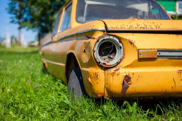 Old yellow wrecked car in vintage style. Abandoned rusty yellow car. — Stock Photo, Image