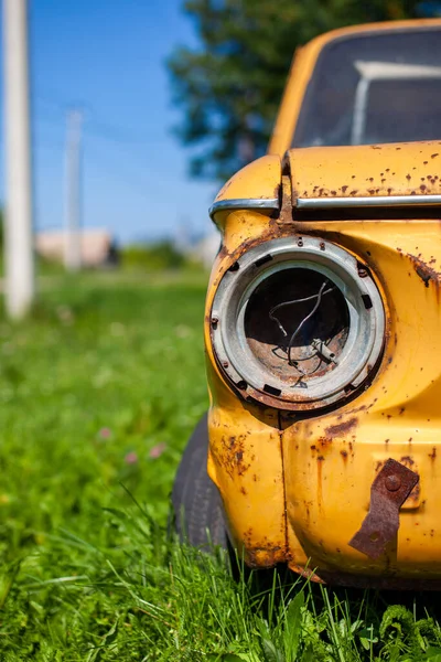 Old yellow wrecked car in vintage style. Abandoned rusty yellow car. — Stock Photo, Image