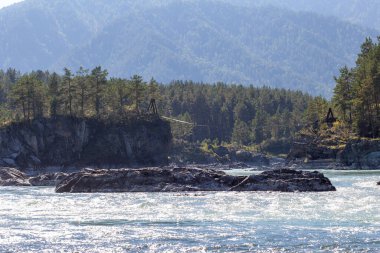 Hızlı akan geniş ve tamamen akan bir dağ nehri. Büyük kayalar sudan dışarı çıkar. Büyük dağ nehri Katun, turkuaz renk, Altai Dağları, Altai Cumhuriyeti.